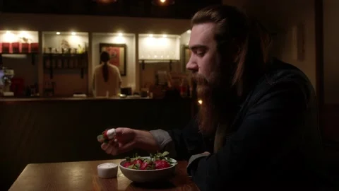 A man eats a large strawberry Stock Footage 223881301