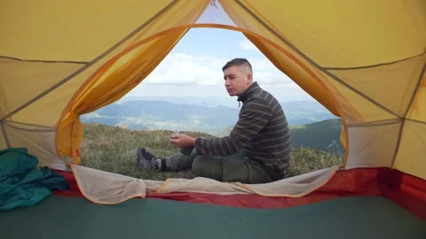 Man eats near the tent, camera movement, shot through the tent, tourist lunch Stock Footage 218440699