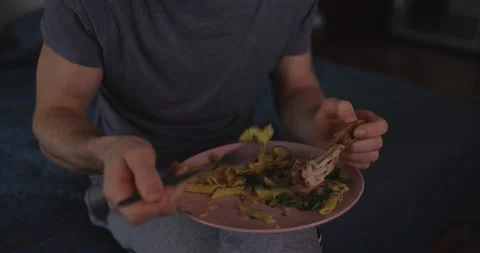 Man eats pasta and watches tv at home Stock Footage 147555931
