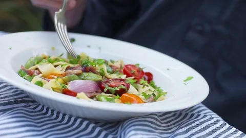 Man eats pasta with vegetables Stock Footage 74902760