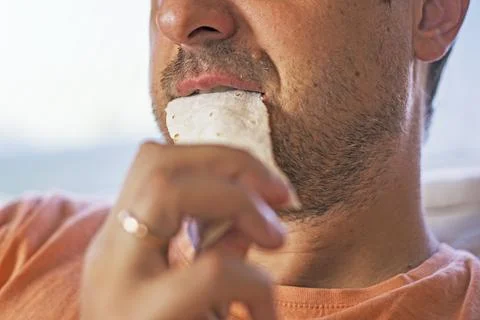 Man eats a piece of thin lavash made from durum wheat Foto stock