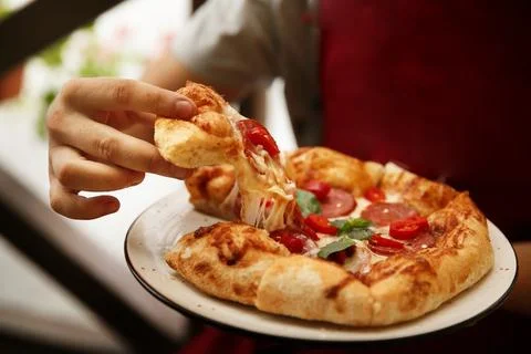 Man eats pizza in restaurant. Stock Photos