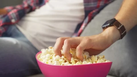 Man eats popcorn and watches tv. Stock Footage 221261362