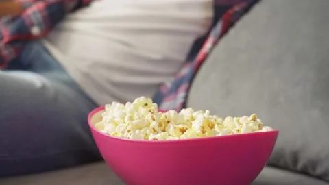 Man eats popcorn and watches tv. Stock Footage 221397640