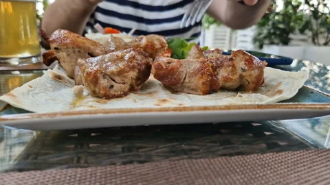 A man eats pork kebab in a restaurant. Video stock 246903295