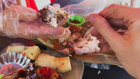 Man eats rice with fork while lady enjoys meal with glove Stock Footage 308916235