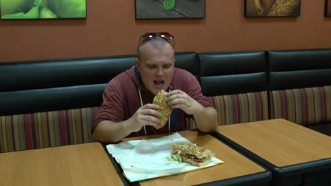 Man eats a sandwich at the Cafe Stock Footage 100615765