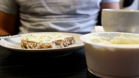 Man eats slice of bread with cheese then drink from cup Stock Footage 96850271
