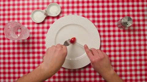 Man eats small green peas with a knife and fork. Extreme diet concept Stock Footage 263859900
