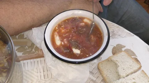 A man eats soup from a plate Stock Footage 148333359