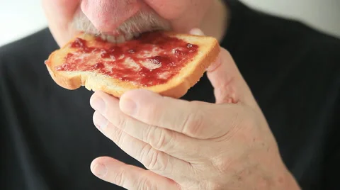 Man eats toast with jam Stock Footage 64860464