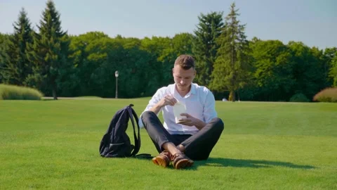 Man eats vegetarian lunch with an ecological package, shows a like and smiles Stock Footage 130486567