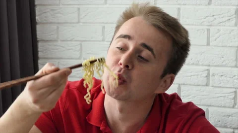 A man eats vermicelli, fast food pasta. The guy eats noodles funny. Close-up Stock Footage 195127665