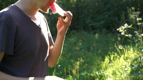 Man eats a watermelon on a sunny day Video stock 98633496