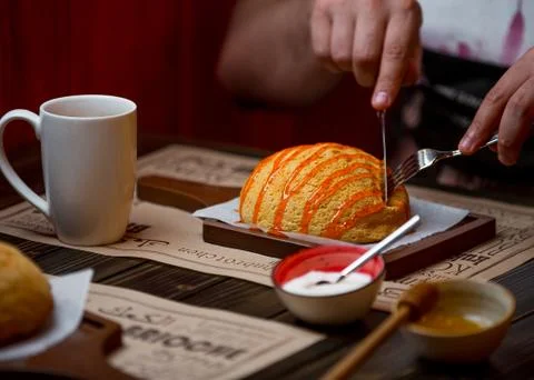 Man eats a white bread topped with caramel Foto stock