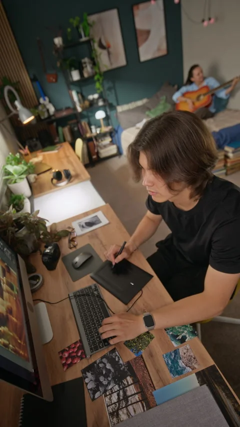 Man Editing Photos on Computer Using Graphics Tablet at Home Vídeo Stock 341951145
