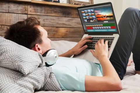 Man editing video with a laptop computer at home. Stock Photos