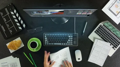 A man is editing video, using the editing program. View from above on the table. Video stock 77666136