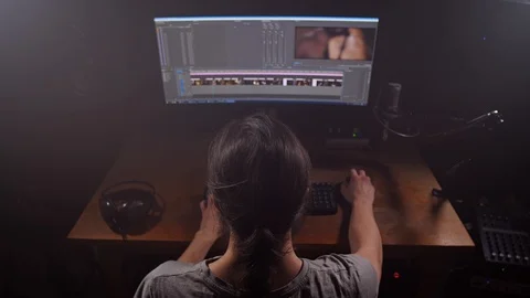 The man is an editor. Working on the creation of the video. In front of him is a Stock-Footage 105288512