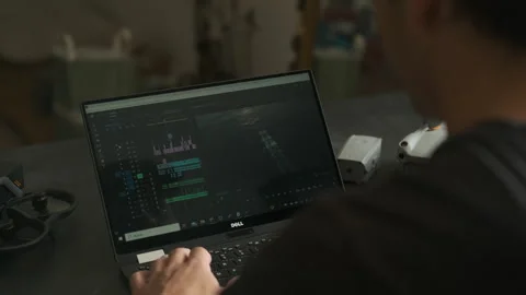 Man edits a video in a room. Drones on the table. Stock Footage 243424210