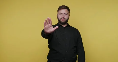 Man educates audience on important topic using hand signals in front of yel.. Stock-Footage 326789221