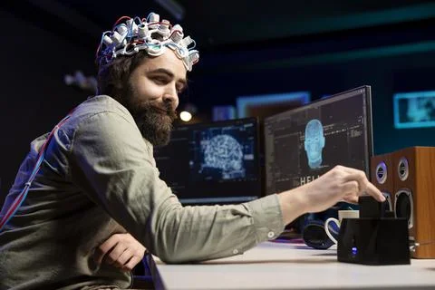 Man with EEG headset inserts disk into PC containing software making AI sentient 写真素材
