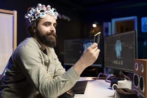 Man with EEG headset inserts disk into PC containing software making AI sentient 写真素材