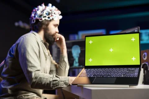 Man with EEG headset transferring mind into virtual world, chroma key laptop Stock Photos