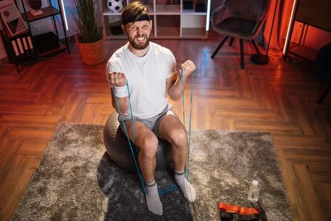 Man with effort on face training with resistance band Stock Photos