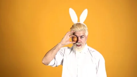 Man with egg on easter. Funny guy wearing bunny ears. Stock Footage 142549590