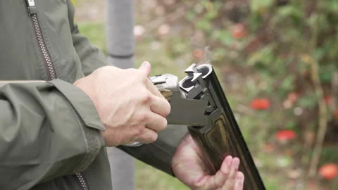 Man ejects shotgun cartridges from gun barrels smoke forced out close up Stockbeeldmateriaal 346261353