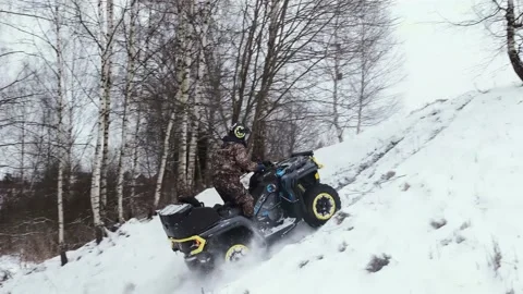A man on an electric custom ATV BRP climbs a mountain in winter. Stock Footage 161178151