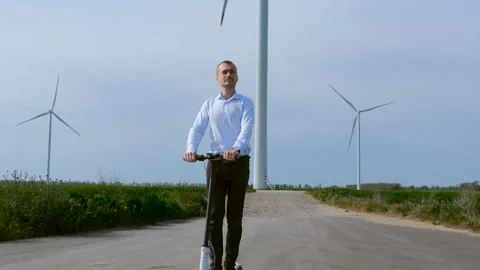 A man on an electric scooter left the windmill. Stock Footage 134163362