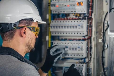 Man, an electrical technician working in a switchboard with fuses. Foto stock