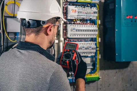 Man, an electrical technician working in a switchboard with fuses. Foto stock