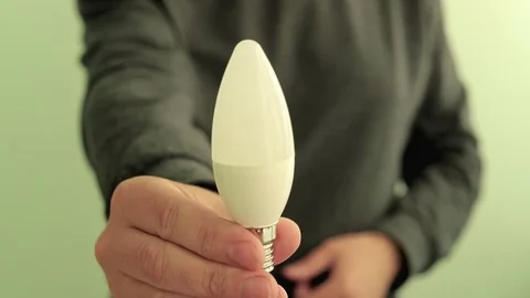 Man electrician engineer give to the camera energy saving LED lamp. Video stock 107426030
