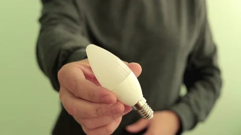 Man electrician engineer give to the camera energy saving LED lamp. Stock Footage 107426046