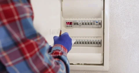 Man electrician writes voltage data checking electrical panel 動画素材 302028591