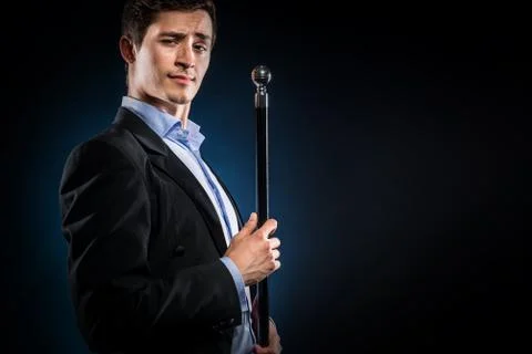 Man in elegant black jacket and blue shirt holding cane Stock Photos