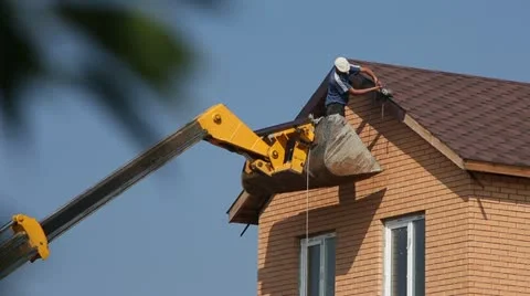 The man on the elevator repairs, builds a house roof Stock Footage 22007443