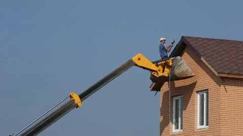 The man on the elevator repairs, builds a house roof Stock Footage 22007485