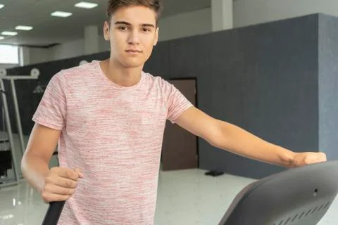 Man on an elliptical machine. Client in the gym doing cardio exercises Stock Photos