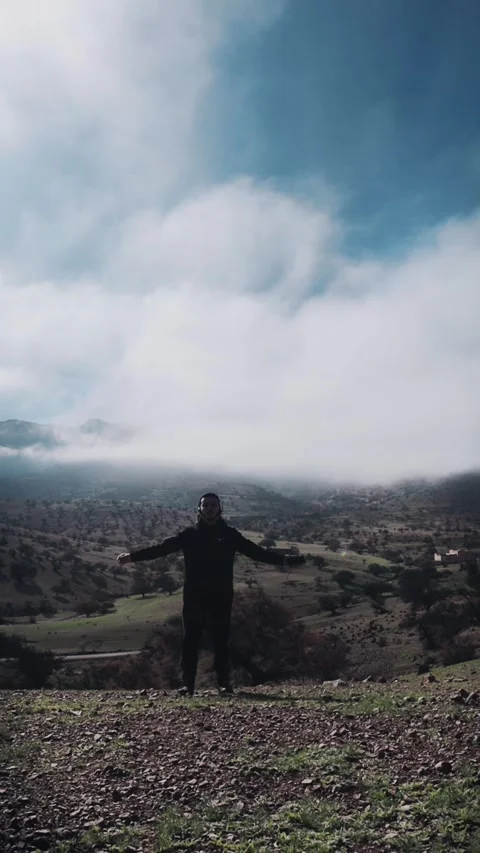 Man Embracing Freedom on Cloudy Mountain, Ait Issafen, Morocco Stock Footage 332776640