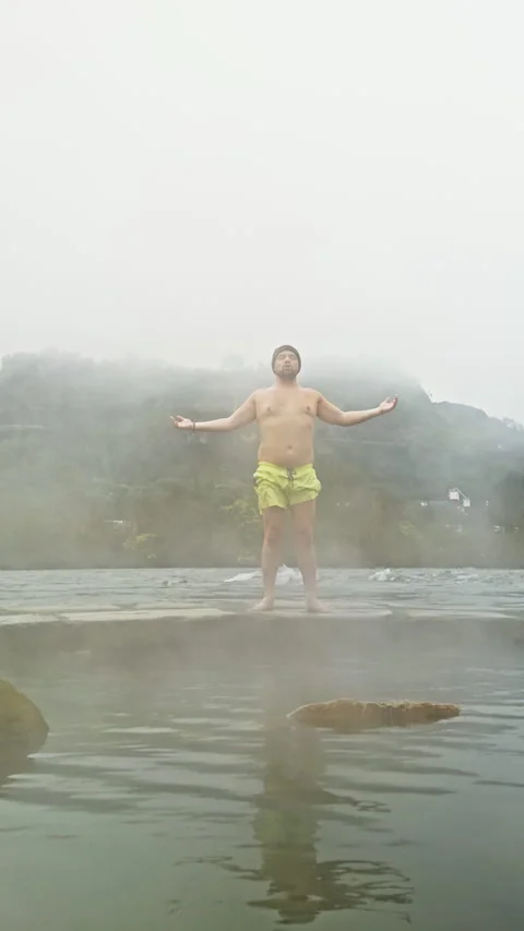 Man embracing nature by hot spring on foggy morning Stock Footage 277740160