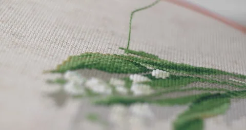 A man is embroidering with a cross on the canvas Stock Footage 146361220
