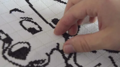 A man embroiders with black threads a monochrome picture. Stock Footage 130400913