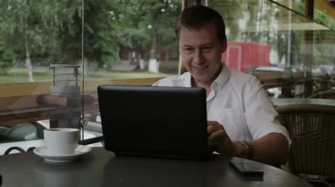 Man emotionally communicates via the Internet using a laptop sitting in a summer Video stock 68170446