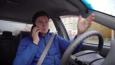 A man is emotionally talking on the phone while driving a car. Stock Footage 81232785