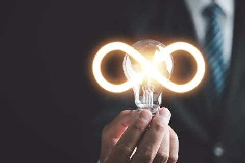 Man emphasizes light bulb with infinite symbol icon Stock Photos