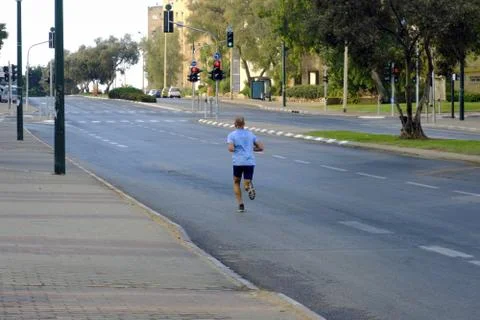 Man on an empty road young runs Stock Photos